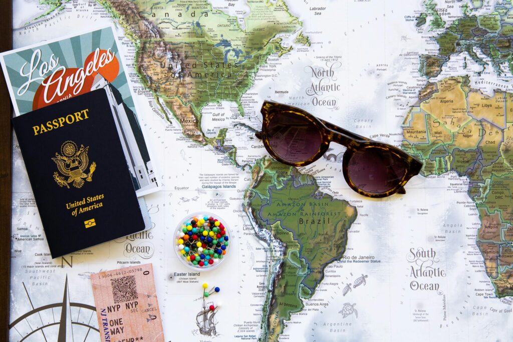 mapa mundial con un pasaporte encima y unas gafas de sol